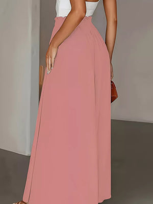 Pale blush wide-leg pants with paperbag waist and a flowing silhouette.