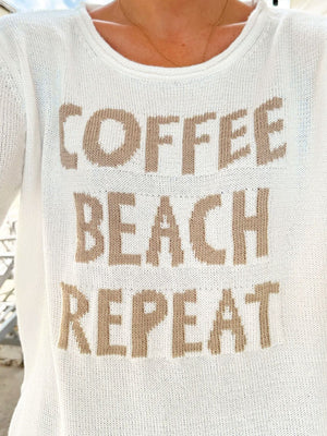 White knit jumper with "Coffee Beach Repeat" text detail.