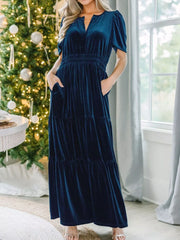 Navy blue velvet maxi dress with pockets, tiered skirt, and short puff sleeves.