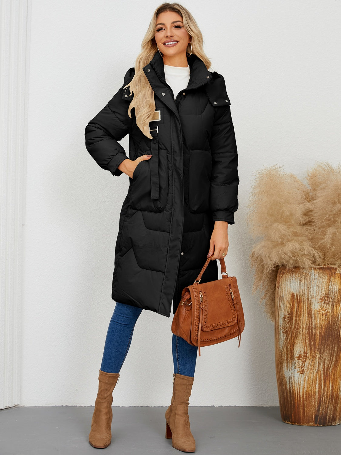 Black quilted puffer parka with hood and buckle detail, mid-length.