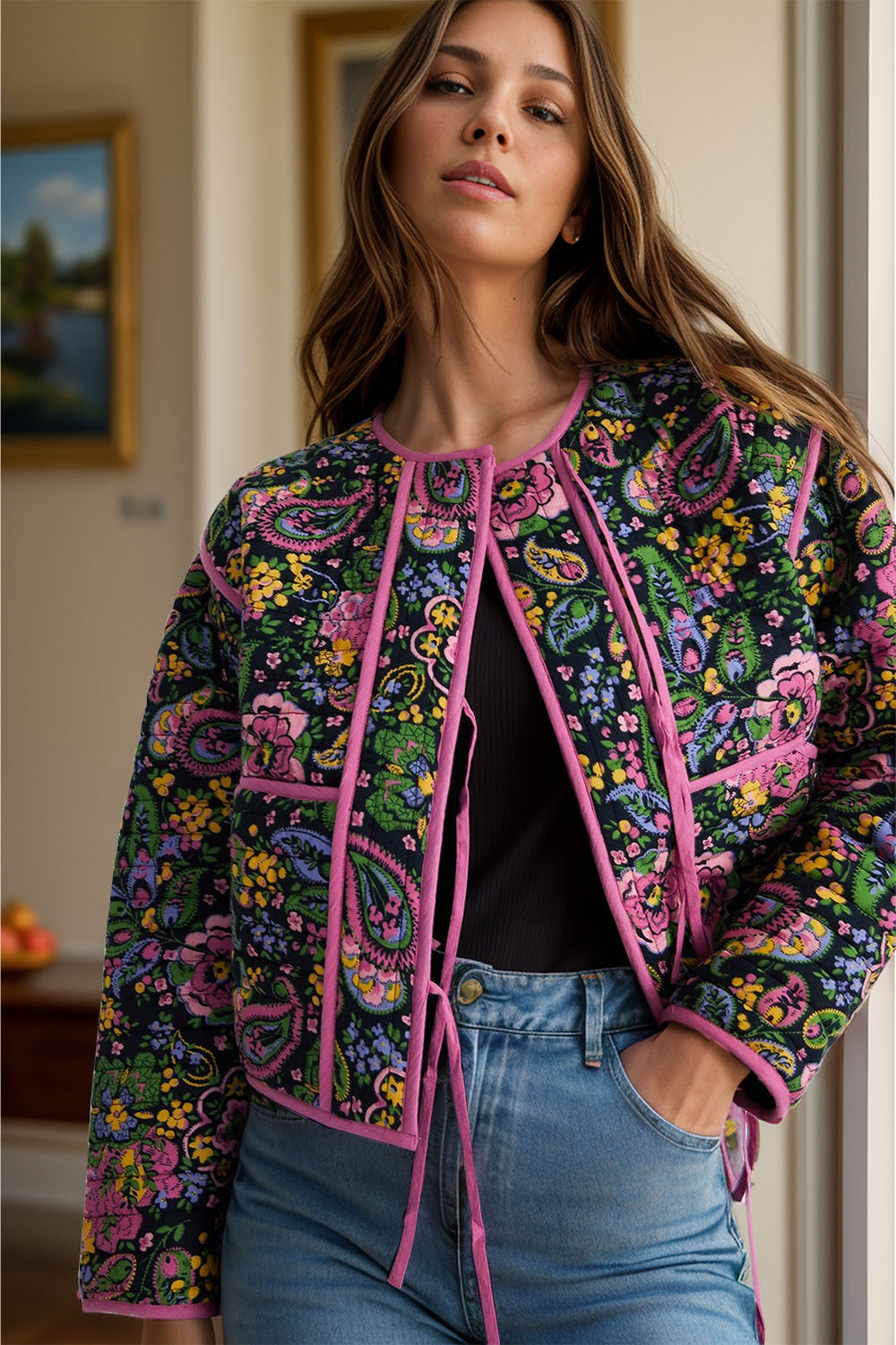 Paisley quilted jacket with tie closure and pink trim, featuring a colorful floral pattern.