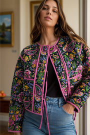 Paisley quilted jacket with tie closure and pink trim, featuring a colorful floral pattern.