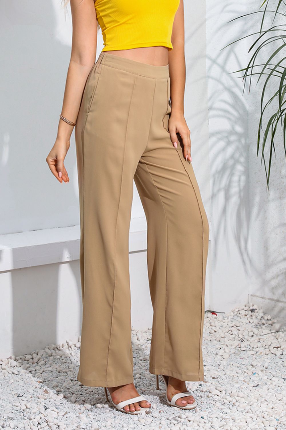 Seamed wide-leg trousers in tan with a high waist, styled with a yellow crop top.