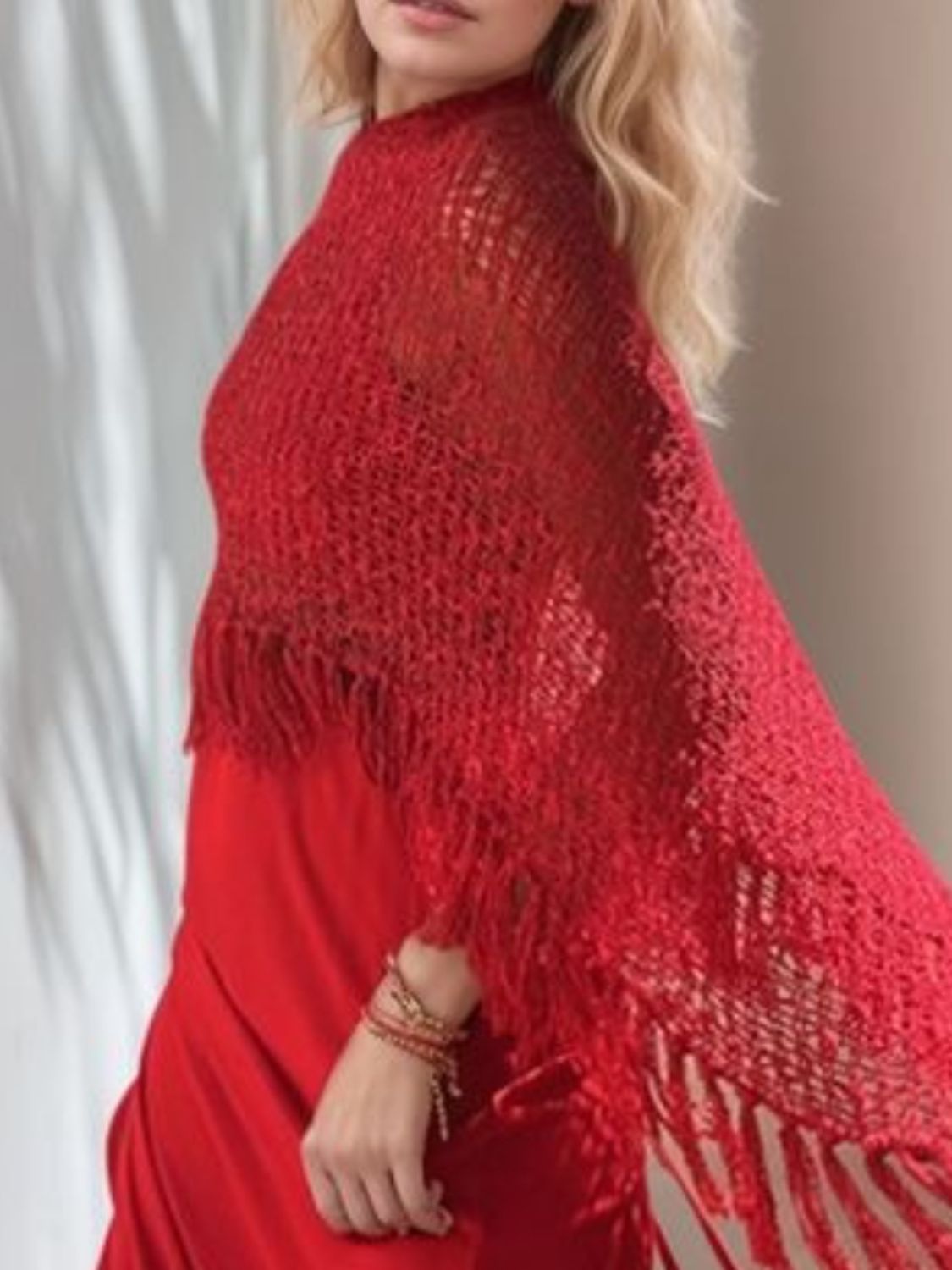 Deep Red open-knit acrylic poncho with fringe trim and boat neckline.