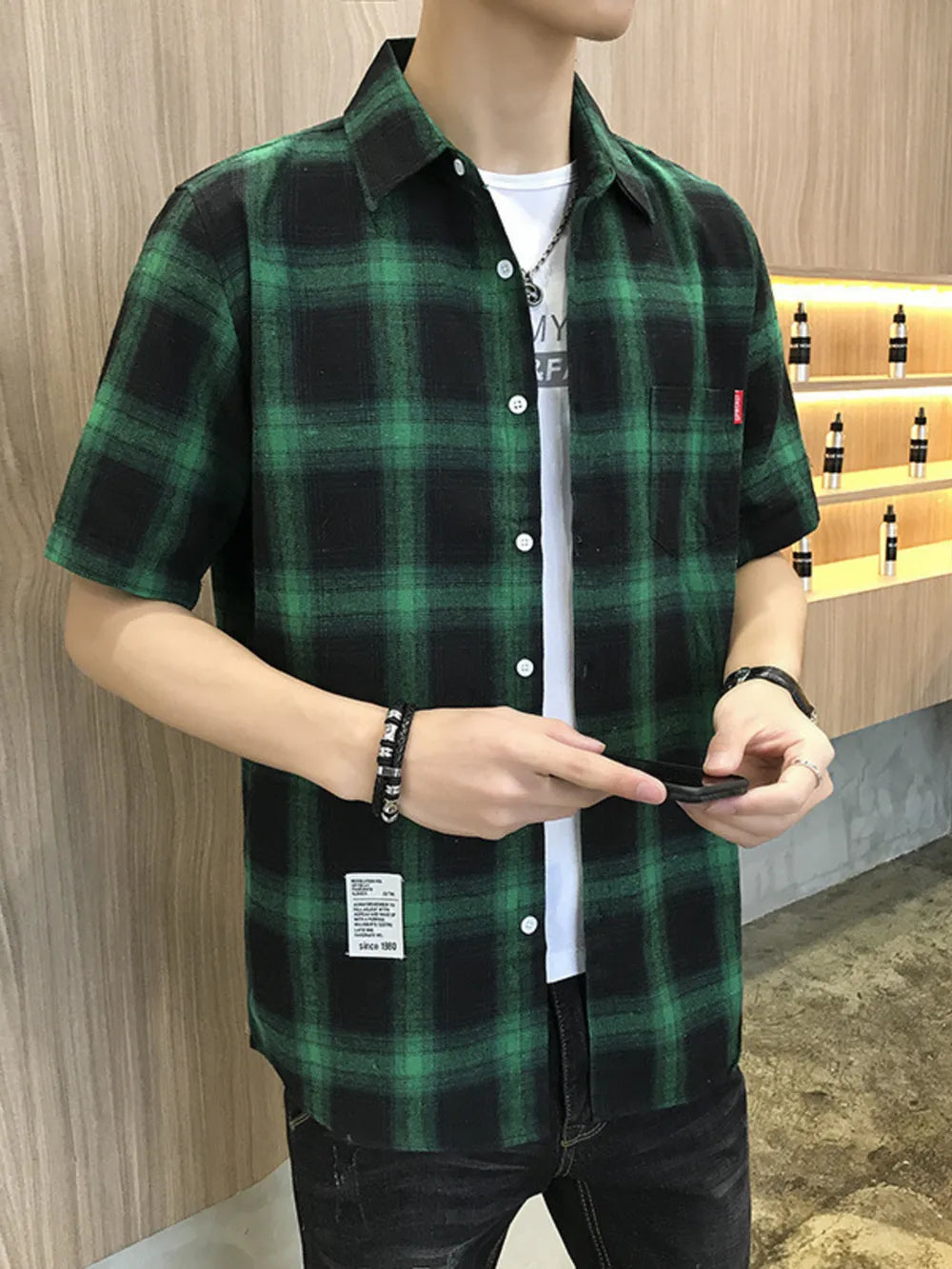 Green plaid short sleeve button-down overshirt with a chest pocket.