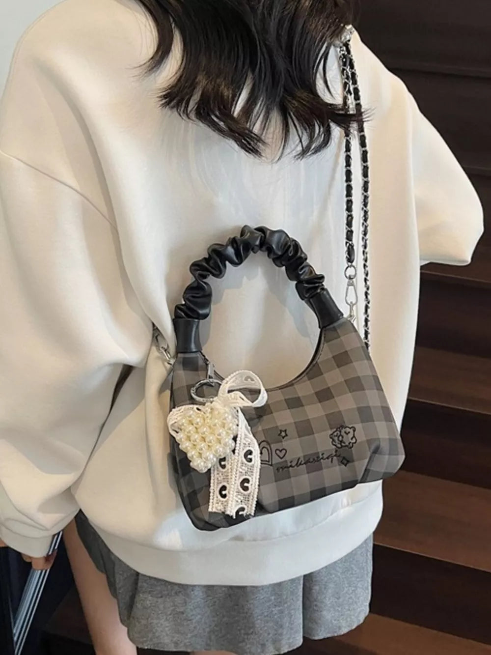 Charming mini crossbody bag in black gingham with ruched handle and pearl heart charm.