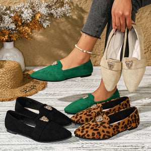 Point toe slip-on flats in green, black, apricot, and animal print with gold lion embellishment.
