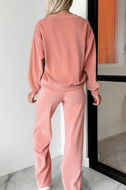 Pink corduroy lounge set with relaxed fit sweatshirt and wide leg pants.
