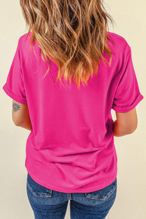 Hot pink t-shirt with rolled sleeves and a relaxed fit, styled with jeans.