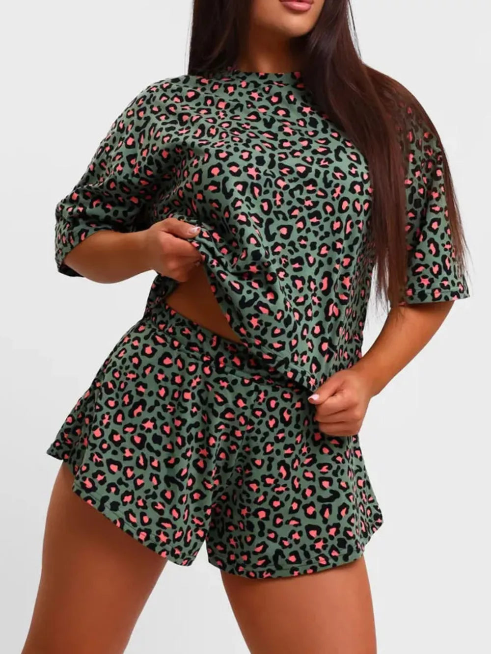 Vibrant leopard print lounge set with green and pink pattern, featuring a short-sleeve top and ruffled shorts.