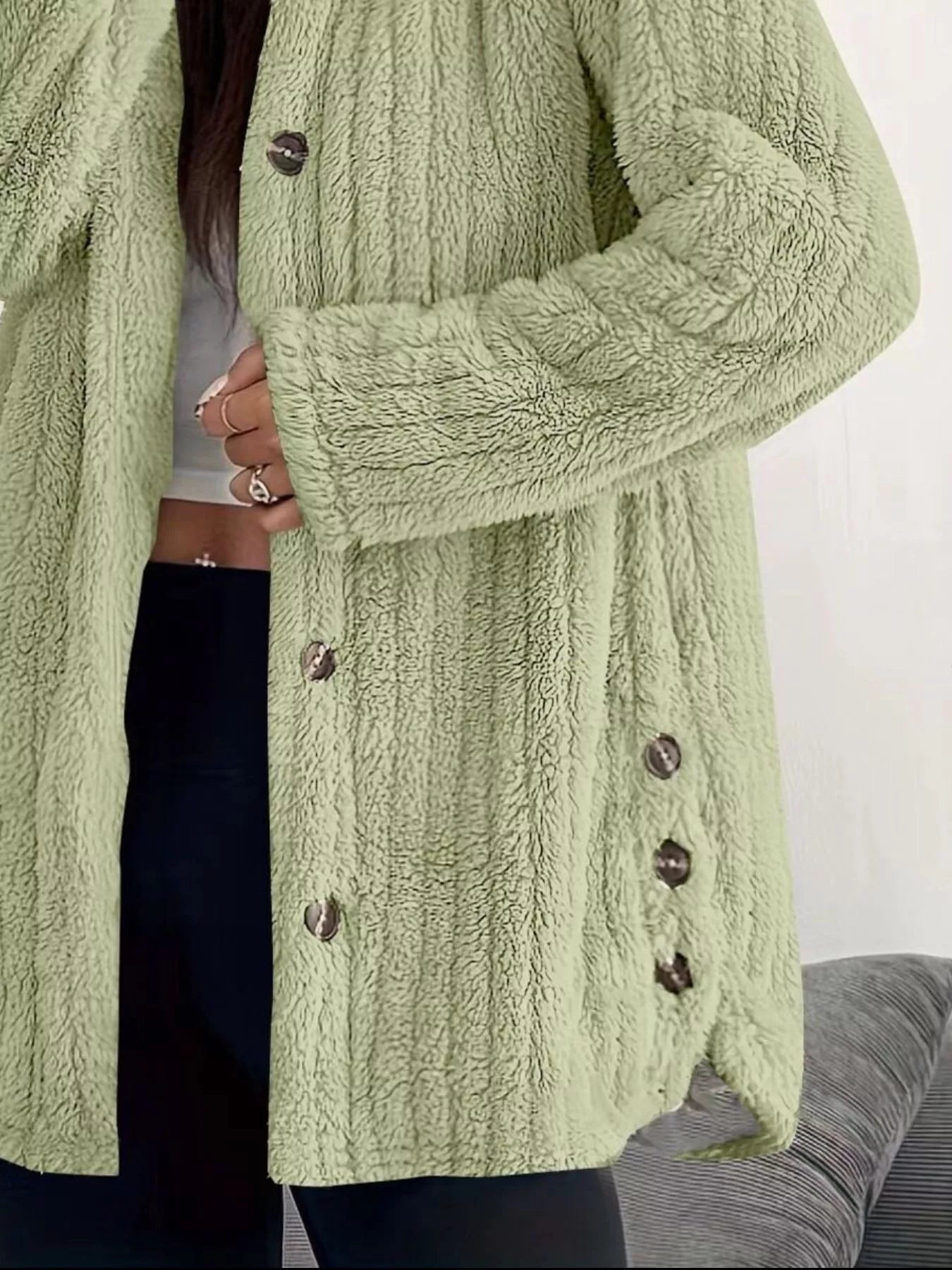 Green button-up fleece jacket with textured fabric and dark buttons.