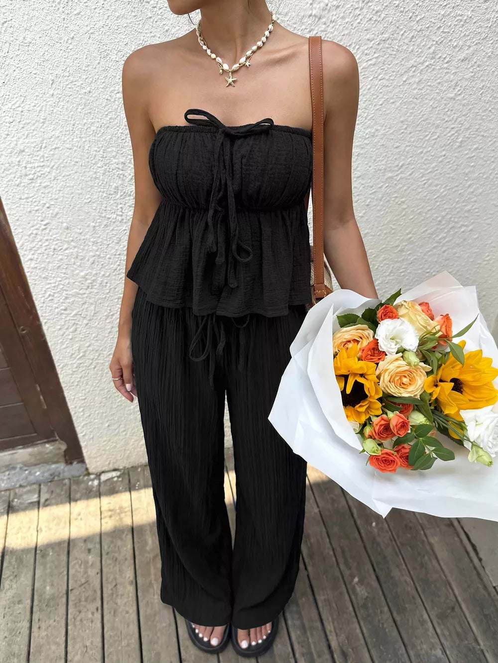 Black tube top with tie detail and wide-leg pants set.