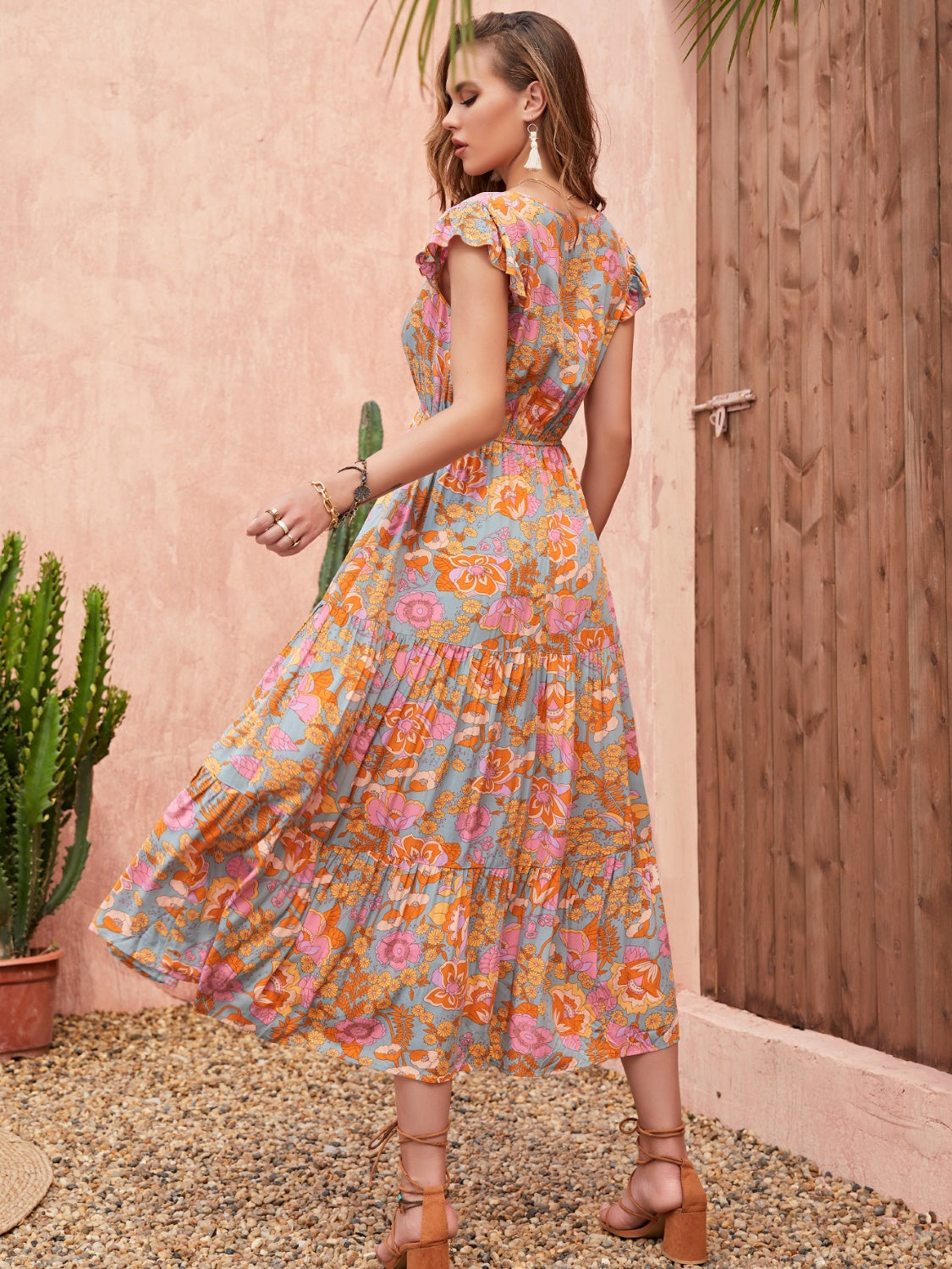Bohemian floral tiered midi dress with flutter sleeves and a multicolor print.