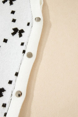 White knit tank sweater with black diamond bow pattern and silver snap closures.