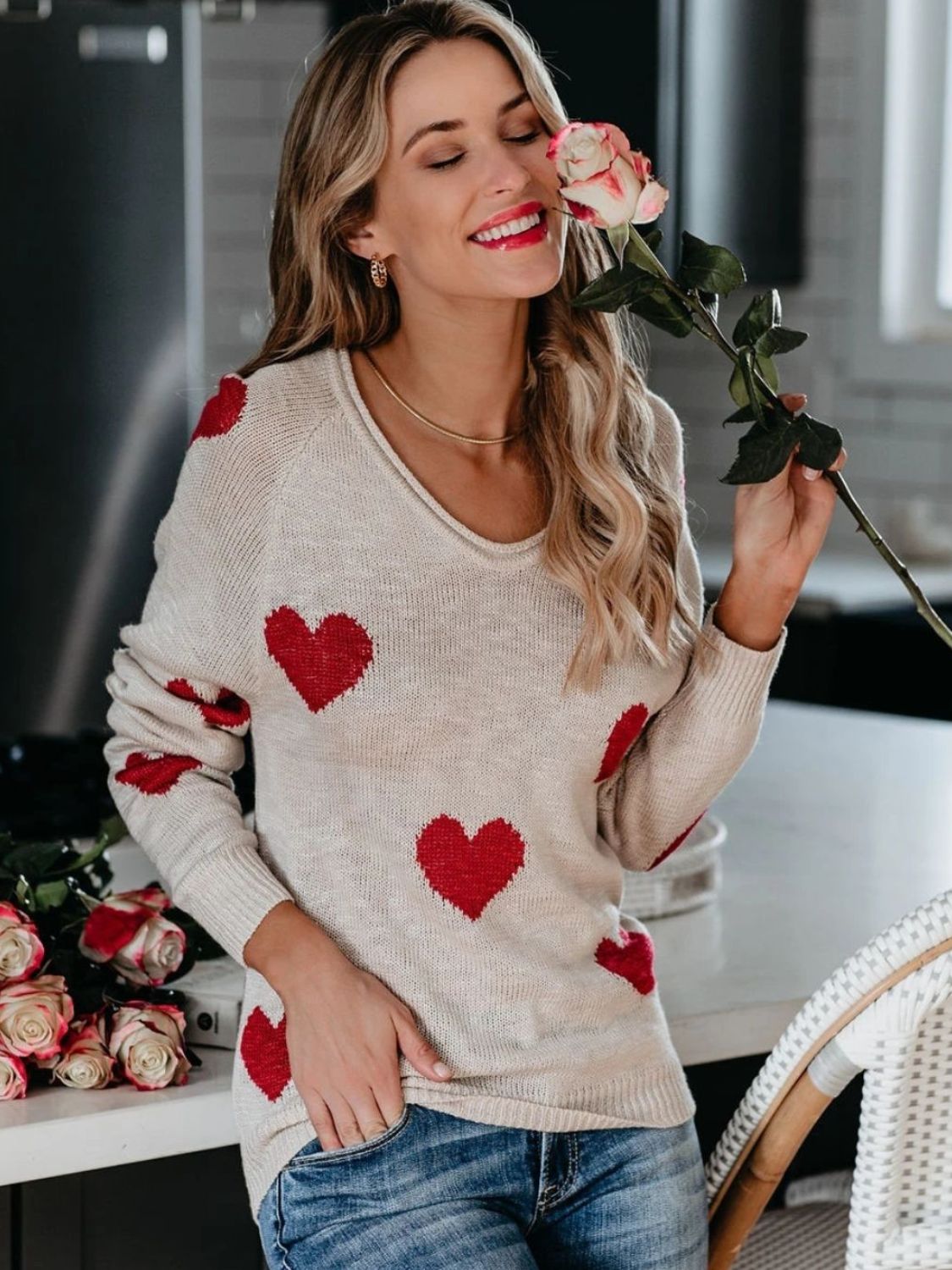 Eggshell knit sweater with red hearts, V-neck, long sleeves, casual style.