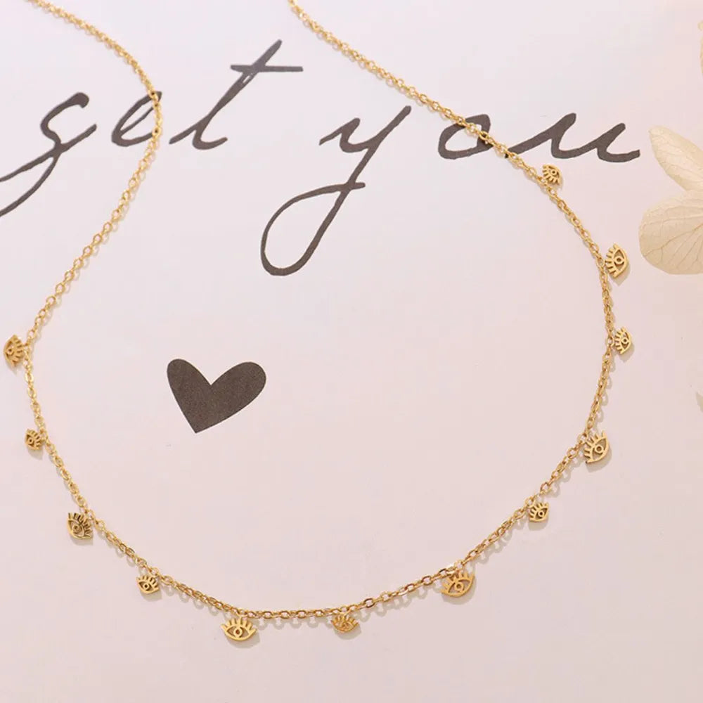 Gold dangling charm chain necklace with multiple eye charms.