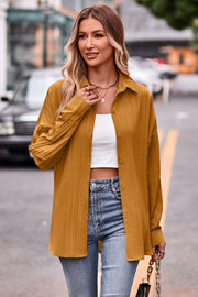 Textured mustard oversized shirt with button front and tie back detail, styled with a white crop top and jeans.