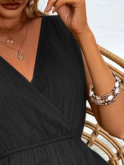 Black textured wrap-front romper with V-neck and elastic waist detail.