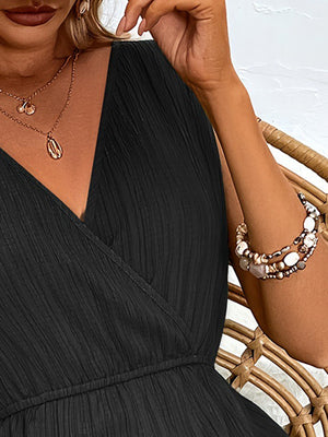 Black textured wrap-front romper with V-neck and elastic waist detail.