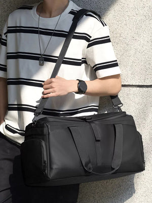 Black Oxford cloth travel bag with side pocket and dual handles.