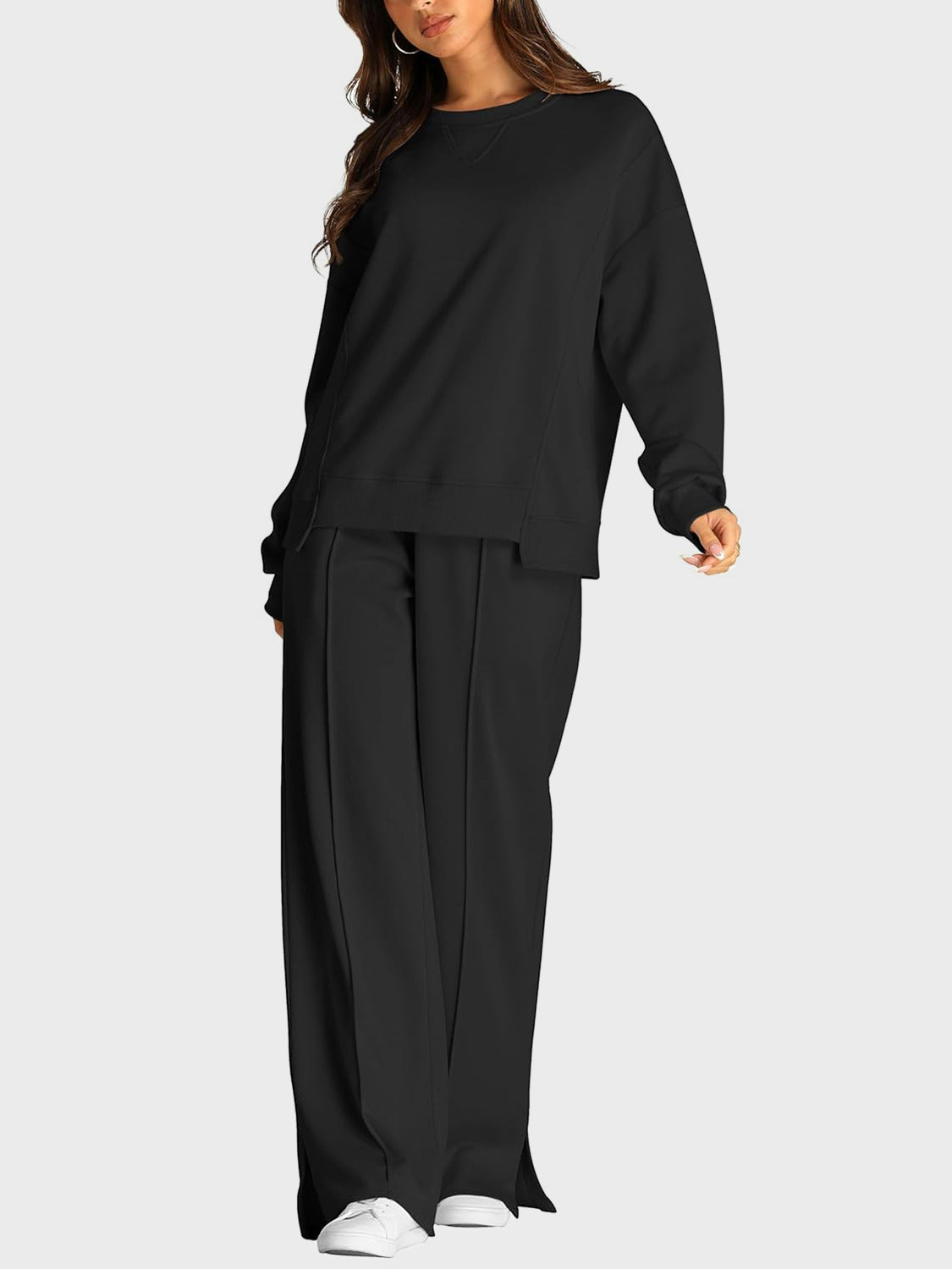 Black seamed loungewear set with crewneck sweatshirt and slit-front wide-leg trousers.