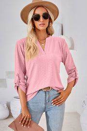 Textured pink henley shirt with roll-tab sleeves and a V-neckline.