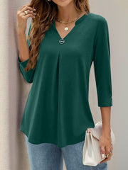 Dark green V-neck three-quarter sleeve top with front pleats and a decorative button detail.