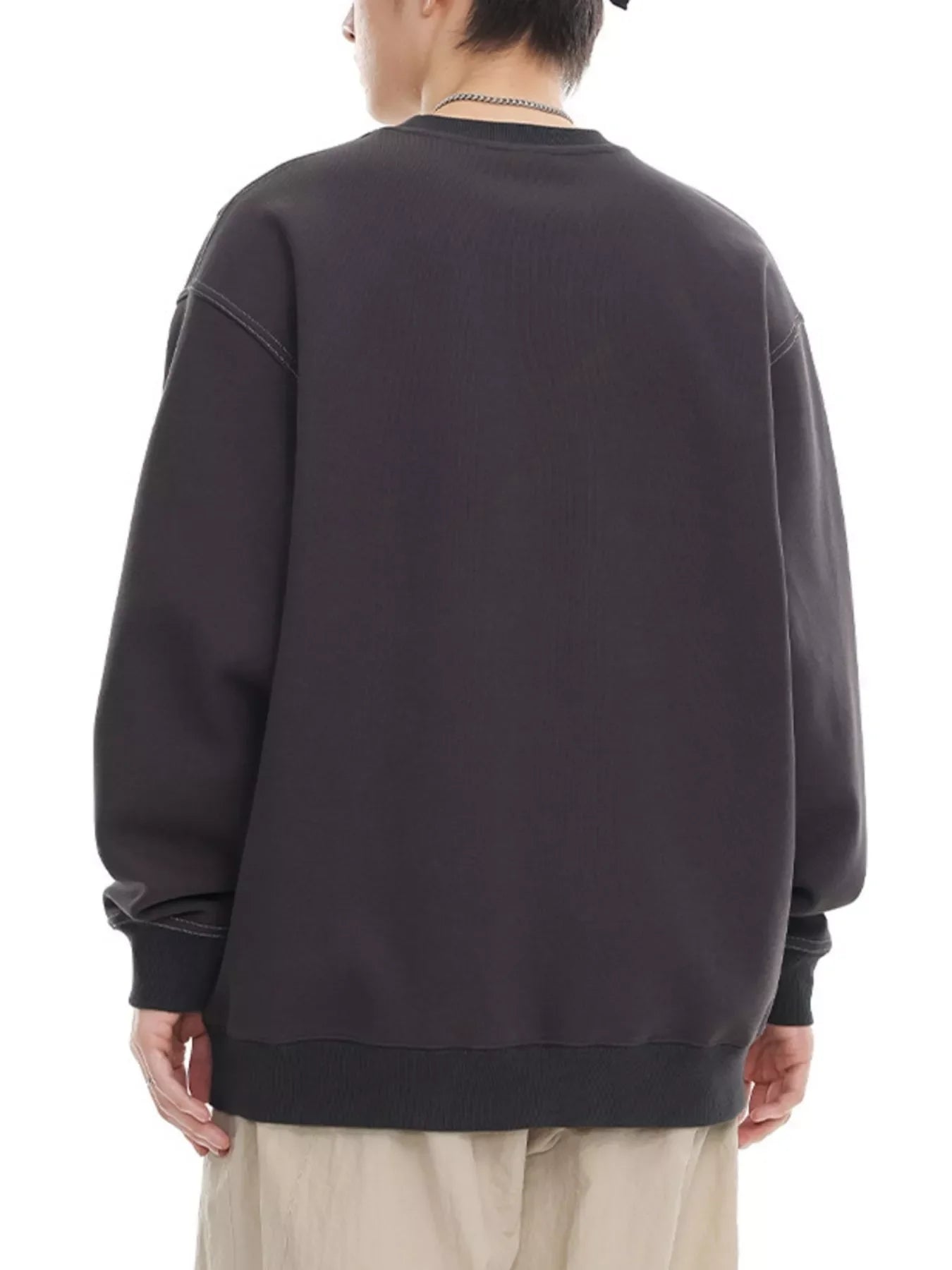 Oversized dark gray long-sleeve sweatshirt with crewneck and ribbed cuffs and hem.