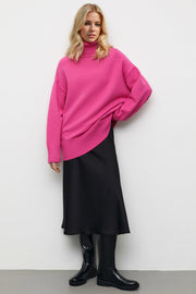 Oversized turtleneck knit sweater in vibrant hot pink with ribbed cuffs and hem.