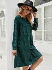 Cable knit A-line sweater dress in Black Forest green with crew neck and long sleeves.