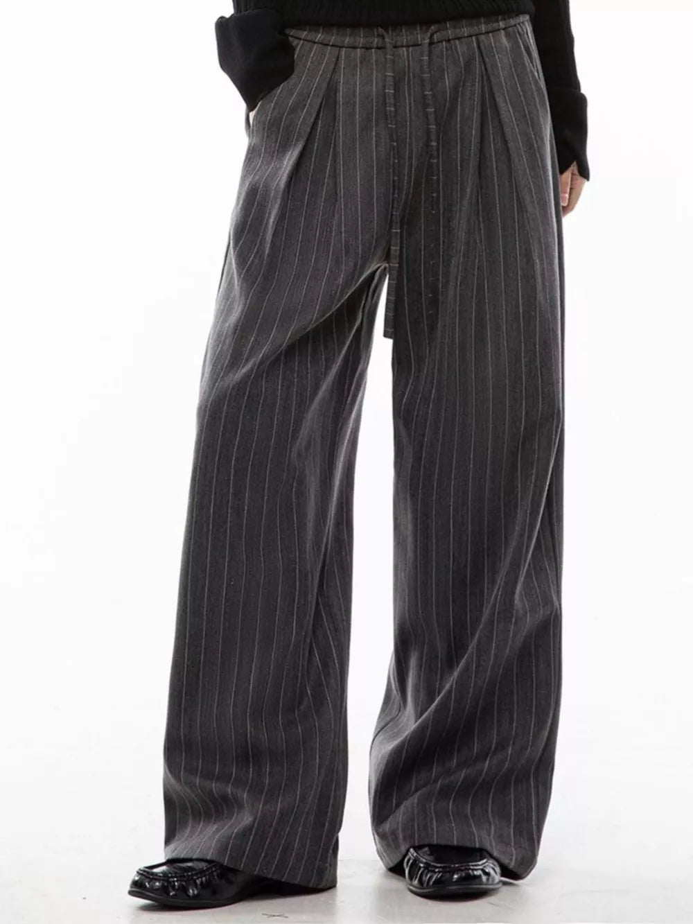 Men's grey pinstripe wide-leg pleated trousers with drawstring waist.