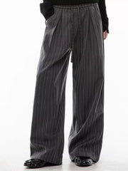 Men's grey pinstripe wide-leg pleated trousers with drawstring waist.