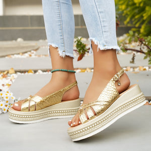 Gold crocodile-embossed platform sandals with crisscross straps and adjustable buckle.