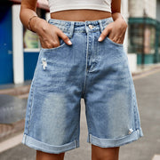 Medium wash denim shorts with rolled hems and distressed details.