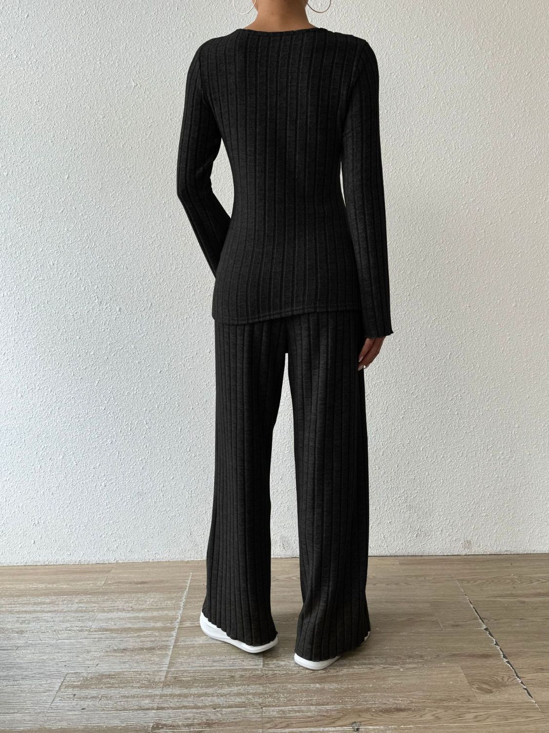 Black ribbed knit loungewear set with long sleeves and flared pants.