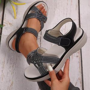Black woven criss-cross platform sandals with adjustable straps and white stitching detail.