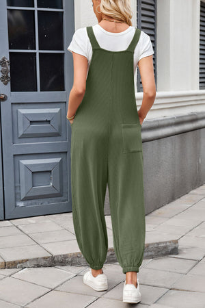 Olive green corduroy overalls with barrel leg and back pockets, worn with a white t-shirt.