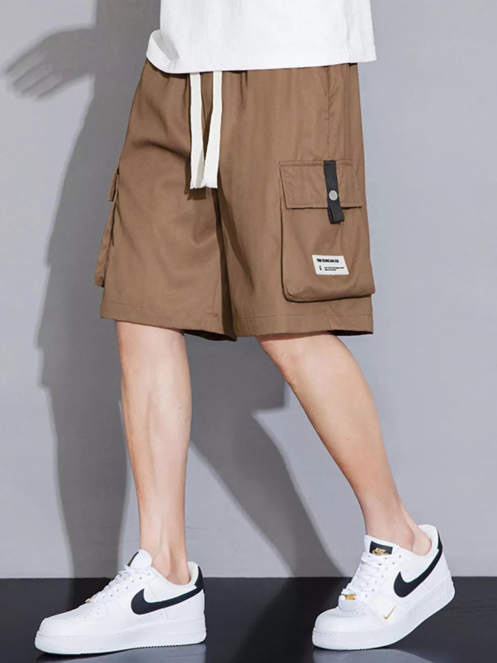 Brown cargo shorts with white drawstring and side pocket detail.