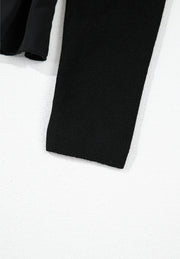 Black ribbed bodice peplum top with a ruffled hem detail.