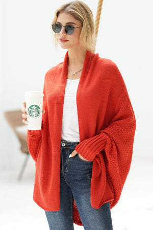Red batwing knit cardigan with draped front and ribbed cuffs.