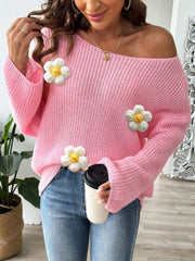 Pink slouchy knit sweater with floral appliqués and off-the-shoulder neckline.