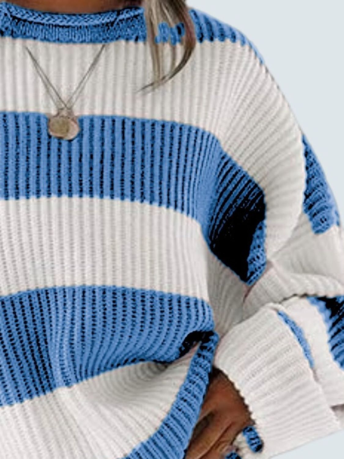 Striped oversized knit sweater in blue and white with a crew neck and ribbed details.