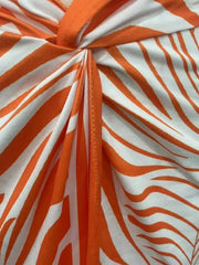 Orange red midi skirt with twisted knot detail and side slit, featuring a zebra print.