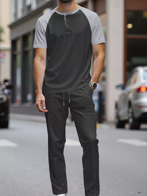 Men's grey and black two-piece loungewear set with drawstring pants and henley shirt.
