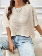Apricot waffle-knit cropped t-shirt with crew neck and short sleeves, styled with jeans.