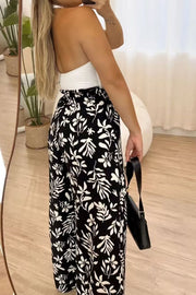 Black botanical ruffle waist palazzo trousers with wide legs.
