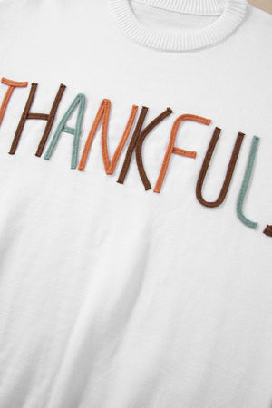 White drop shoulder sweater with "Thankful" embroidery in multi-color yarn.