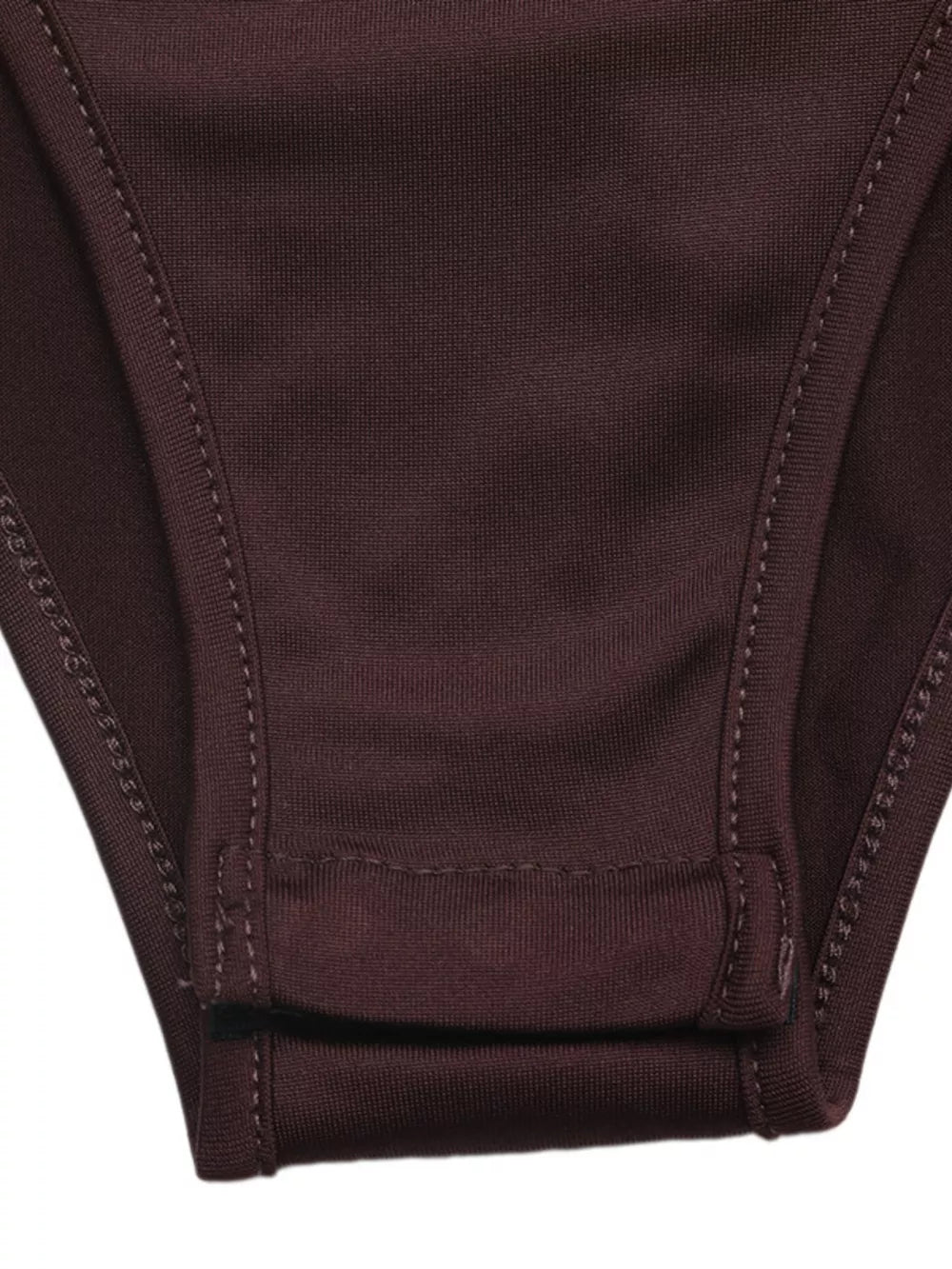 Bodysuit detail showing snap closure and stitching on dark brown fabric.