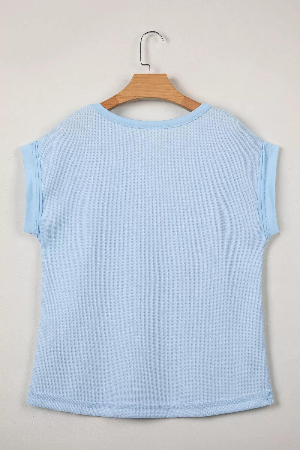 Light blue waffle knit t-shirt with cuffed sleeves and curved hem.