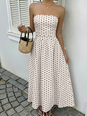 Chic white polka dot A-line maxi dress with a strapless neckline and cinched waist.